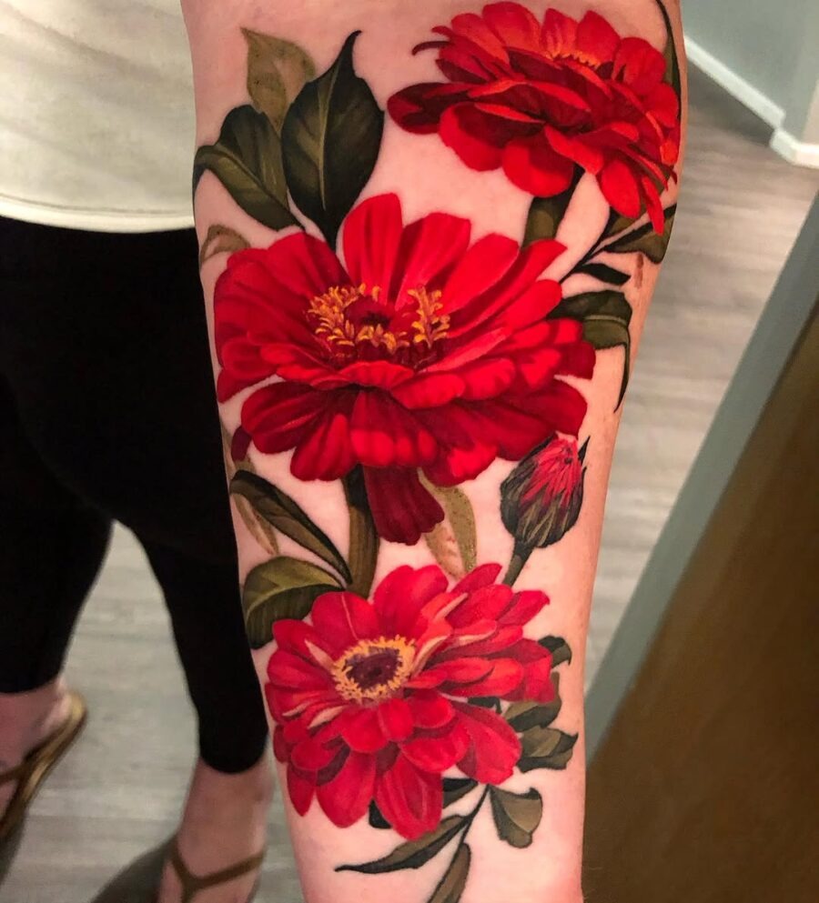 Bold red zinnia tattoo with lush green leaves Tattoo Design
