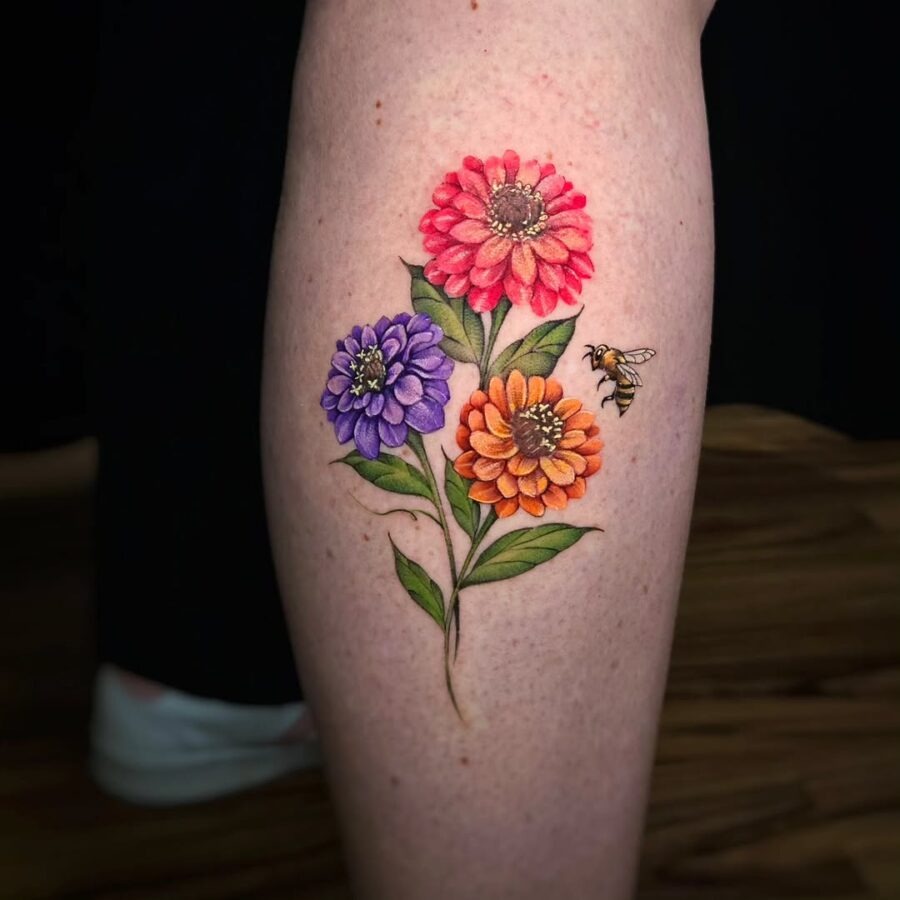 Vibrant zinnia tattoo with a charming bee Tattoo Design